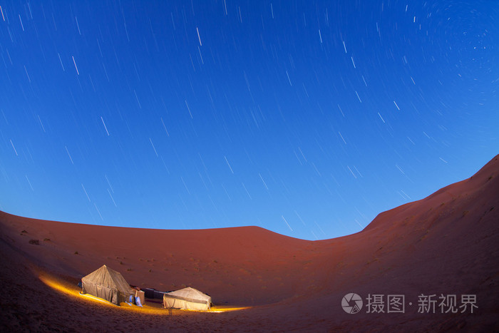 在撒哈拉沙漠在晚上与移动星星照亮的营地