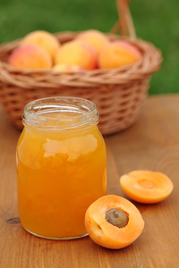 与杏酱和新鲜杏子在篮子里的玻璃
