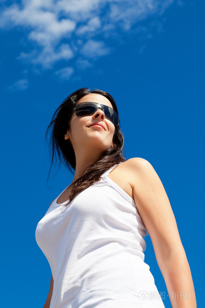 年轻女子微笑与蓝蓝的天空背景