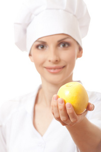 微笑的女人厨师与黄色苹果