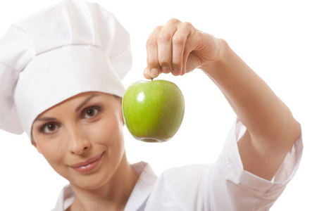 微笑的女人厨师与绿苹果
