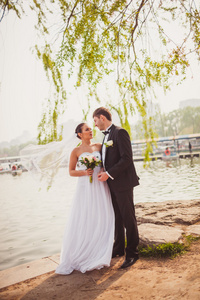 新郎新娘站在靠近湖