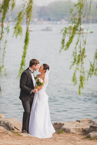 新郎新娘站在靠近湖