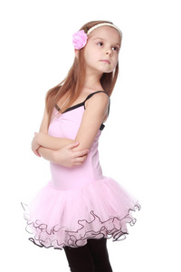 工作室形象的一个迷人的舞者与美丽的头发在粉色的芭蕾舞裙微笑着和在白色背景上跳舞