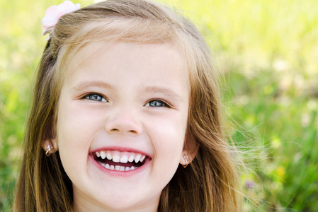 可爱微笑的小女孩在草地上