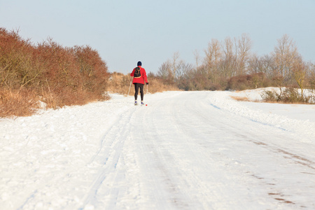 在荷兰冬季风景与蓝色滑雪板和徒步旅行的单身男人