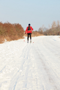 在荷兰冬季风景与蓝色滑雪板和徒步旅行的单身男人