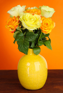 束美丽的橙色背景上桌上花瓶里的玫瑰