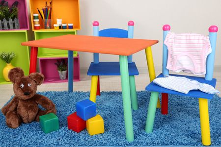 小和多彩的桌子和椅子与婴儿衣服