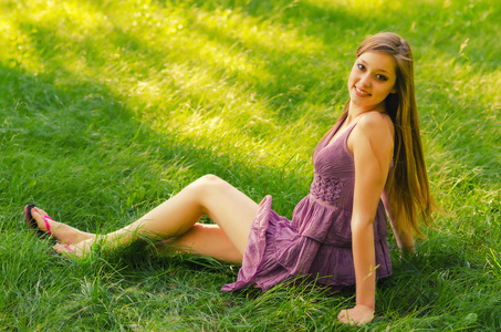 美丽的女孩坐在草地上