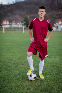 青少年足球球员与球穿红裙子的字段上