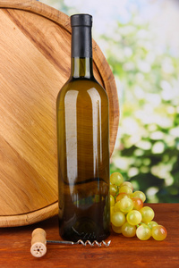 开瓶器和一瓶红酒 葡萄 木桶在明亮的背景上的木桌上的组成