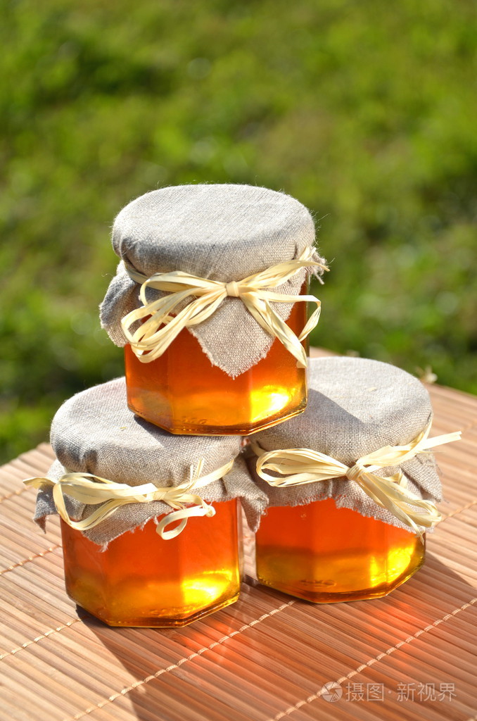 三个罐子装满了美味新鲜蜂蜜