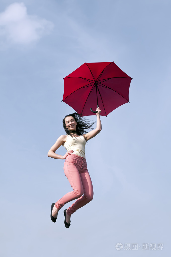 女人用雨伞跳进蓝蓝的天空