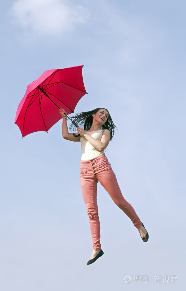 女人用雨伞跳进蓝蓝的天空