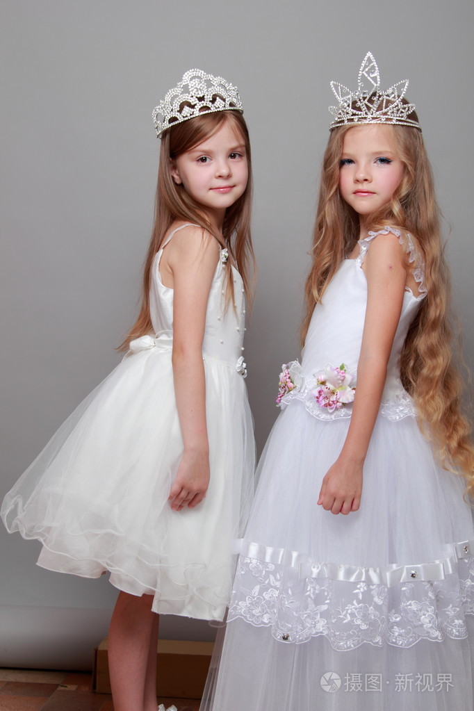 迷人和优雅的小女孩身穿白衣头戴皇冠的美丽和时尚