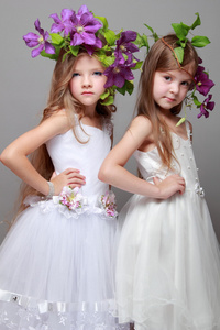 微笑与美丽发型新鲜紫铁线莲的美丽和时尚优雅的礼服的小女孩