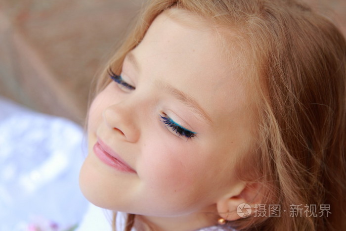 优雅可爱的小女孩在美丽的头发白色礼服化妆