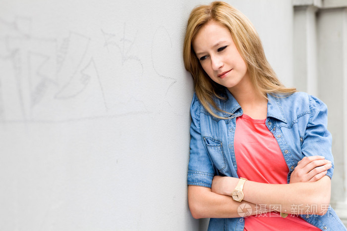 年轻女子倚墙上