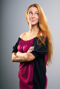 有魅力的年轻女人穿红裙子的红色的长头发