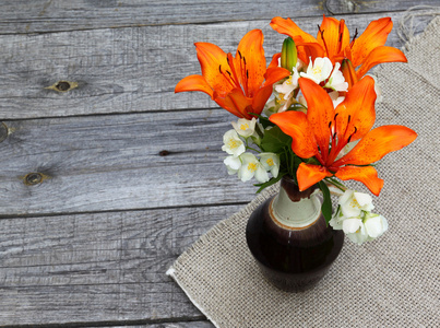 橙色藏红花百合花和木桌上的茉莉花