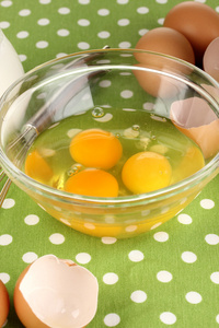 破的蛋在碗和各种成分他们旁边上绿色桌布特写
