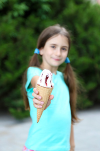 小女孩溜冰鞋在公园背景吃美味的冰淇淋