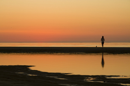 一个女孩上海滩夕阳的剪影
