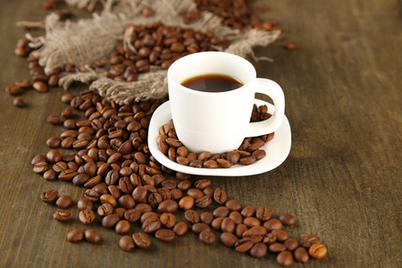 杯咖啡和咖啡豆木制背景上