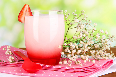 美味的草莓酸奶，在自然背景上的木桌上的玻璃