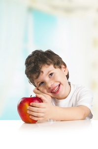微笑的可爱小男孩与一个红苹果