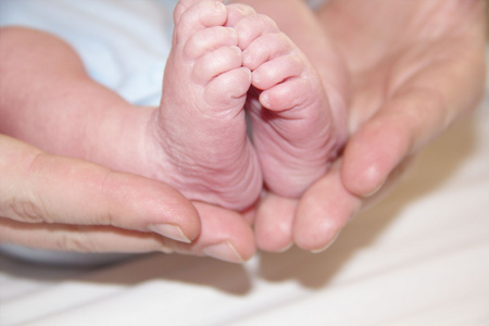 可爱的小小的脚的新生婴儿手中的老爸