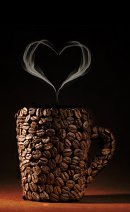 喝杯咖啡与烟气中棕色背景上心的形状