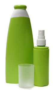 孤立在白色背景上的两个绿色塑料瓶。喷雾瓶。洗发水