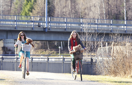 两个女孩骑一辆自行车在公园里