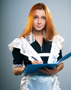 有魅力的年轻女人在学校制服。持有一个蓝色文件夹