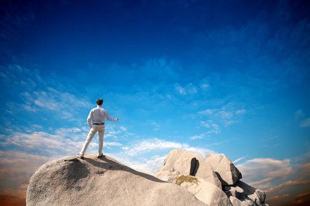 年轻男子站在悬崖的边缘，望着宽阔的山谷
