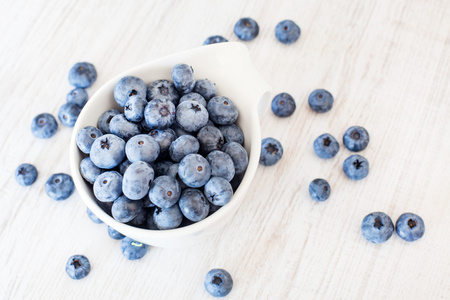 与成熟的新鲜蓝莓白碗杯图片