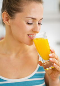 喝鲜橙汁的快乐年轻女人肖像