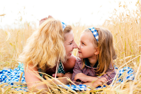 一个女孩和她的母亲在小麦田中