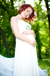 年轻孕妇在白色礼服