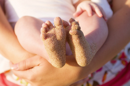 婴儿的脚满海滩沙
