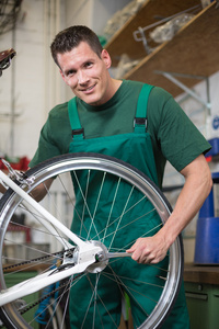 机修工修理车间一辆自行车上的滚轮