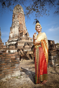 执行典型的泰国舞蹈与泰式寺庙背景的女人