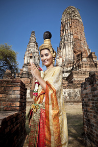 执行典型的泰国舞蹈与泰式寺庙背景的女人