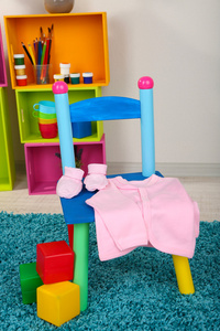 婴儿衣服小和多彩的椅子