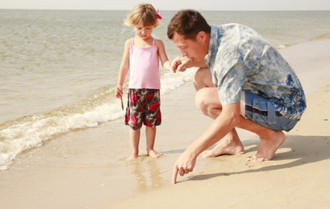 爸爸和小女儿在海滩上