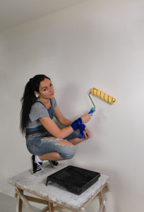 女孩画在她的房子一堵墙