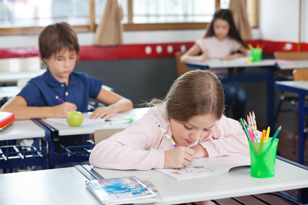 绘图时靠在教室里的桌子上的女学生