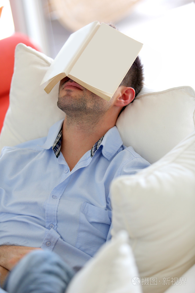本书涵盖了他的脸在沙发睡觉的年轻人